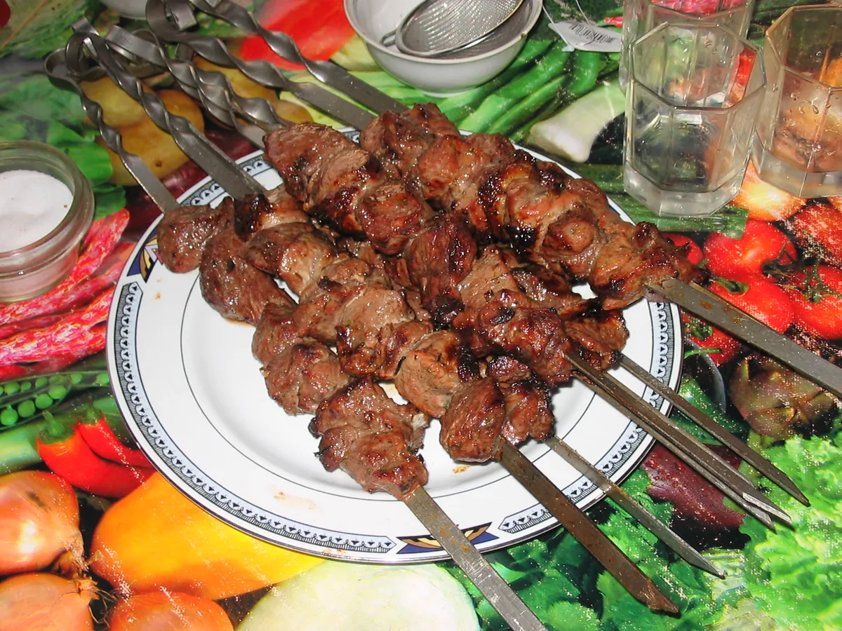 Шашлык на шампурах на тарелке с овощами