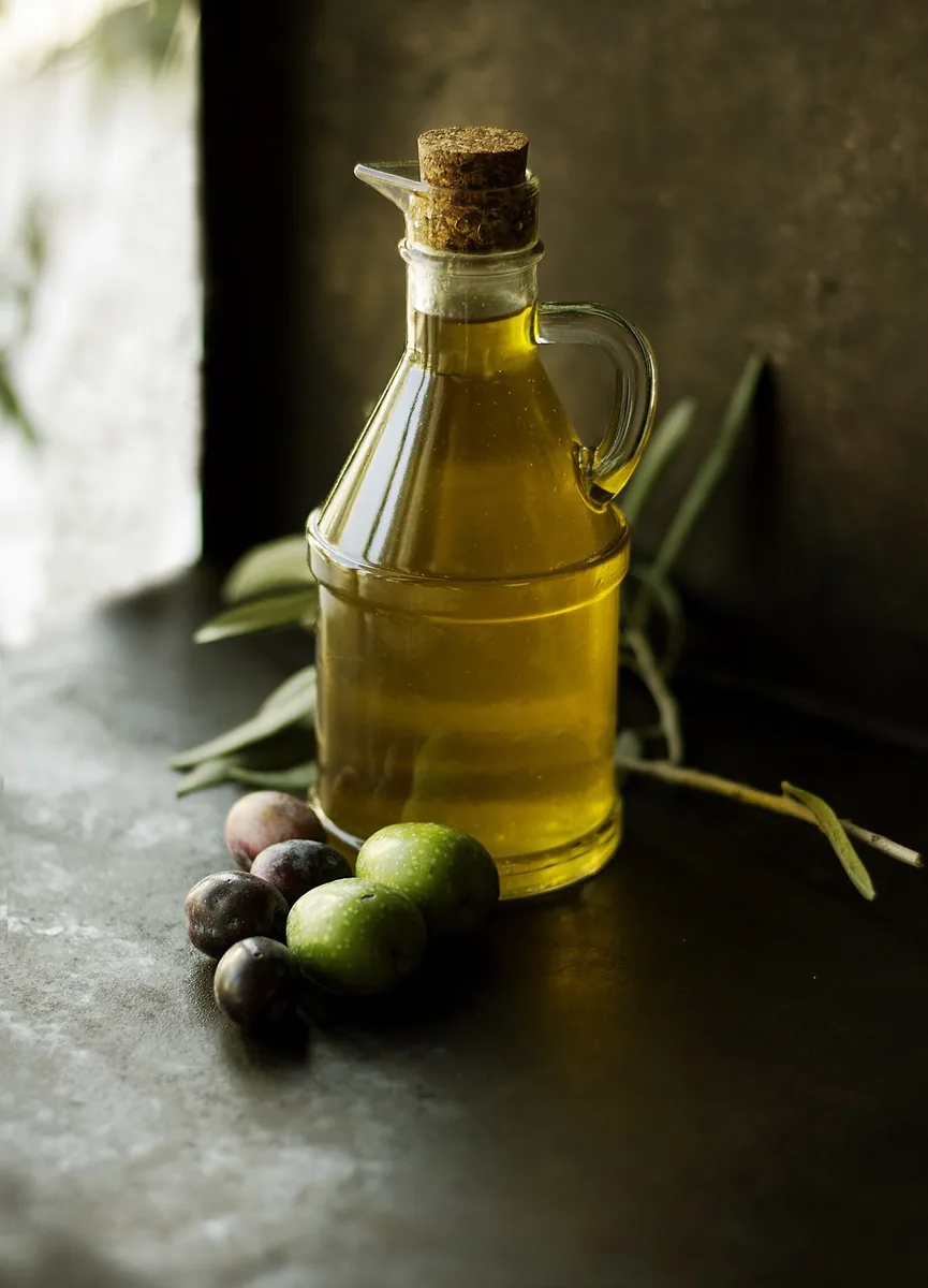 Olive oil in a bottle with olives